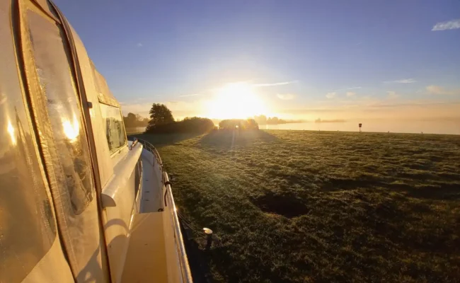 Motorjacht op het water in Friesland bij zonsopkomst